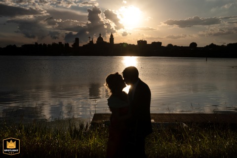 The bride and groom share a kiss at Castello di San Giorgio in Mantova, Italy, silhouetted against the sunset as the fading light creates a striking backdrop.