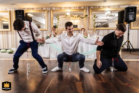 Male guests compete in a humorous game on the dance floor during a wedding reception in Plovdiv, bringing laughter and playful energy to the celebration.