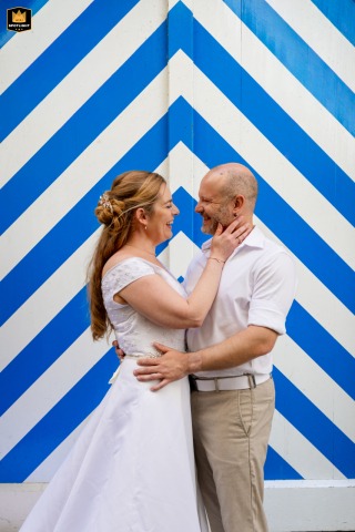 The couple stands together in Lucerne City, framed against a blue and white striped backdrop that creates a striking setting for their wedding photograph.