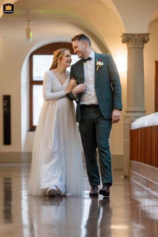 The newlyweds walk together through the corridors of Zurich City Hall following their civil wedding ceremony, sharing a quiet moment together.