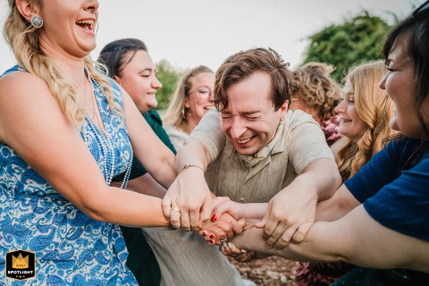 The groom bursts into laughter as his female friends prepare to throw him into the air at Mintrops Landhotel Burgaltendorf in Essen, Germany.