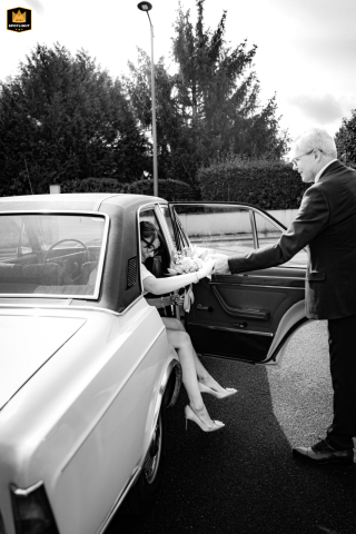 The bride steps out of a car at Mairie d'Angoulême, arriving for the wedding ceremony with anticipation and excitement.