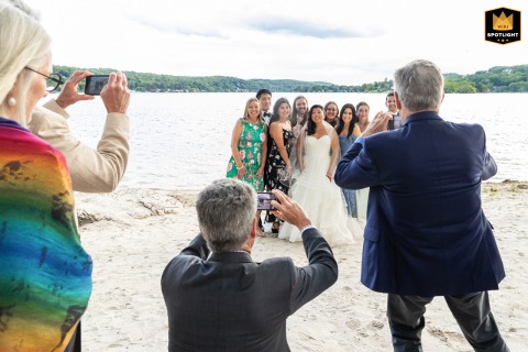 Guests crowd around with cell phones at Lake Mohawk Country Club in Sparta, New Jersey, capturing photos of the bride and her friends.