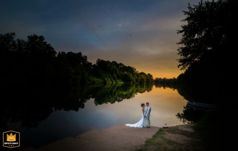 In Bergerac, Dordogne, France, the newlyweds soak in the sunset along the banks of the Dordogne River, their silhouettes softened by the warm evening light.