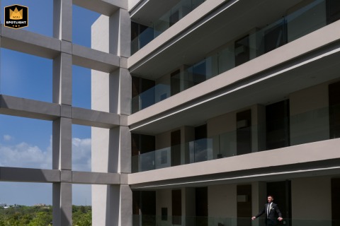 In Playa del Carmen, the groom's portrait uses architecture as a backdrop, giving the image a strong graphic feel while highlighting his tailored look and composed expression.