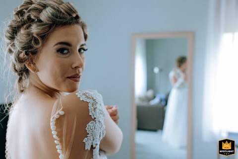 At a hotel in Budapest, a bride glances over her shoulder with quiet anticipation, her elegance and poise shining just moments before the ceremony begins.