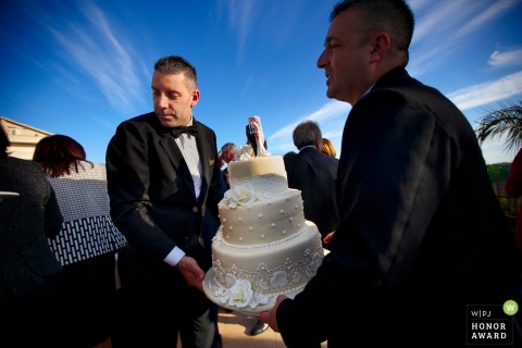 Foto do pessoal do local de recepção carregando o bolo de casamento no Grand Hotel President, Siderno