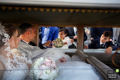 Novia de Reggio Calabria dentro de la limusina con niños mirando adentro - fotógrafo de bodas