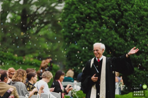 Leesburg, VA wedding photographer - this ceremony officiant enjoys the guests bubbles outside