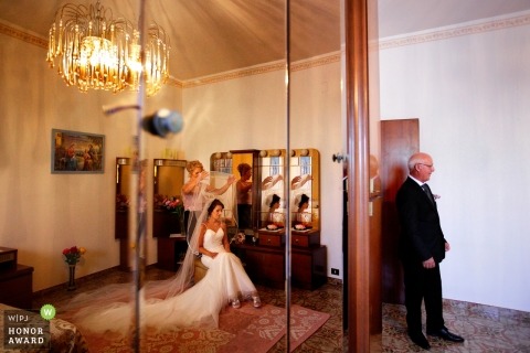 Reflection of the Bride getting ready while her father waits