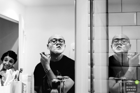 Groom shaving in the mirror with reflections before getting ready for the Paris wedding