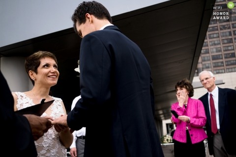 Seattle wedding photojournalism image of a couple during their ceremony exchanging rings