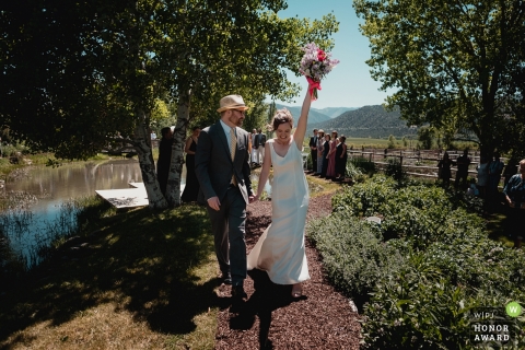  Picture of a bride thrusting her bouquet into the air as she celebrates, by a top Telluride wedding photographer