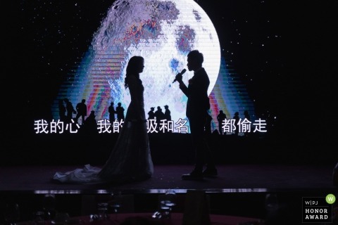 Wedding shoot with Taiwan couple with microphone and large screen behind them on stage