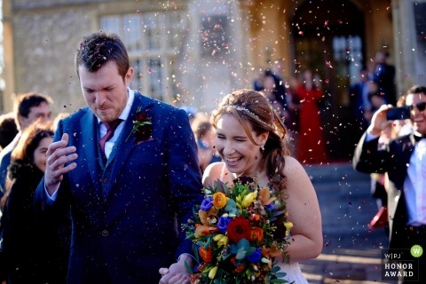 Horsley Towers, Surrey, England | wedding photojournalism image of a couple with wedding confetti emotions 