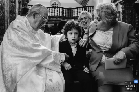  Ouro Preto  documentary wedding photo of the priest talking to a young boy inside the church