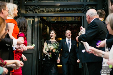 England, Country Hall wedding photo of the	bride and groom leaving ceremony 