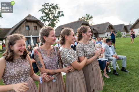 Outdoor wedding ceremony photography from Tešanovci, Slovenia showing the Bridesmaids got their laugh at the ceremony