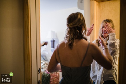 Wedding photography from Camp McDowell, Jasper, AL showing The mother of the bride dries her tears and tries not to cry more after seeing her daughter in her wedding dress