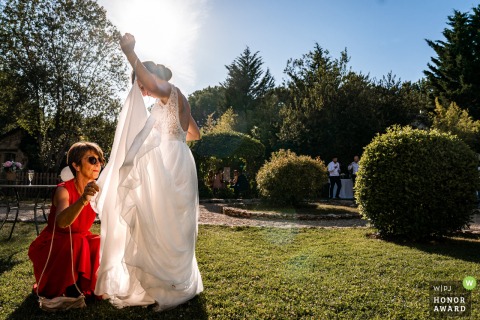 French wedding photography from Ferme De Bouchemont showing the brides dress becoming a Fly trap outdoors in the sun