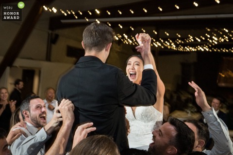 Wedding guests lift up the bride and groom during the reception dance party at Palisades Tahoe, Olympic Valley, CA
