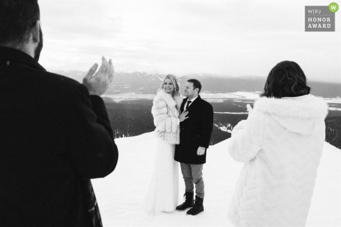 Guests applaud the newlyweds after their outdoor ceremony in the snow in Leadville, Colo.