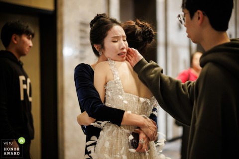 Bride and Mother Share Emotional Embrace Following Wedding Banquet at Home in Foshan, Guangdong, China At a home in Foshan, Guangdong, China, the bride and her mother share an emotional embrace after the wedding banquet.