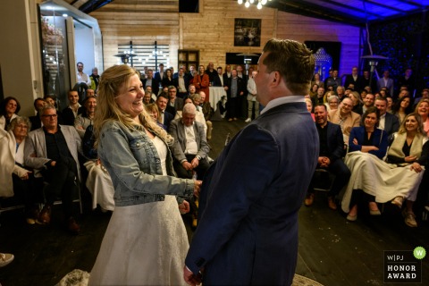 In East Flanders, Belgium, the couple is seen after saying "yes" during their ceremony, with seated guests in the background.