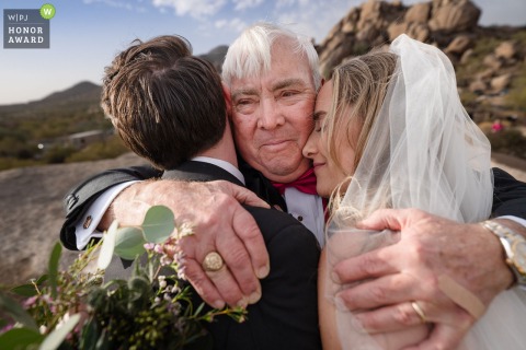 After the ceremony at Boulders Resort & Spa in Arizona, the father of the bride is pictured hugging the couple outside on the day.