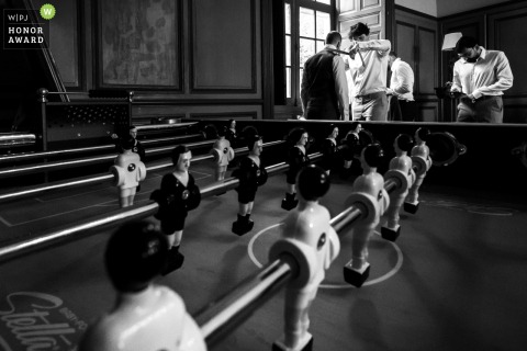 At Domaine de la Dame Blanche in Gironde, France, the groom prepares for his big day in a room featuring a foosball table, adding a playful touch to the morning.