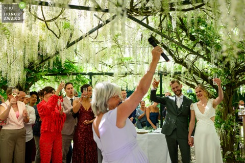 At Wedding Venue Vught in Noord Brabant, the mother of the bride stands and proposes a heartfelt toast, surrounded by beautiful tree canopy scenery and celebrating family.