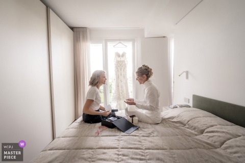 In Vicenza, the bride and her maid of honor share an emotional moment, exchanging gifts and heartfelt notes while getting ready.