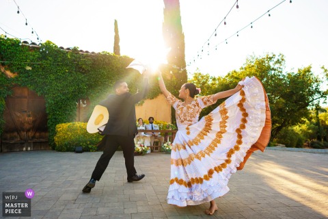 Peruvian dancers in costumes perform a lively traditional dance, entertaining wedding guests at Milagro Winery in Ramona, CA.