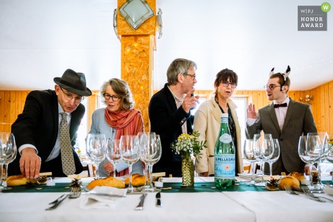 Guests at Gite l'Essentiel in Haut-Breda, France, chat and search for their places at the wedding table, sharing conversation as they prepare for the meal ahead.