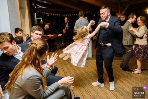 At Gîte l’Essentiel, Haut-Breda, France, during the celebration, a guest lifts and playfully “flies” a child.