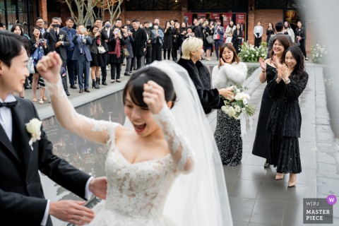 At BRICK YARD 33 1/3 in Taipei, Taiwan, the bride tosses her bouquet to enthusiastic single wedding guests.