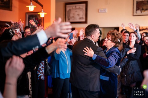   In Trieste, Italy, the groom shares a heartfelt dance with his mother, highlighting the close family connections on this joyous wedding day.