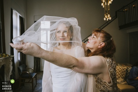   The bride receives gentle support as her mother helps her get ready at Soho House İstanbul, highlighting the strong family bond before the ceremony.