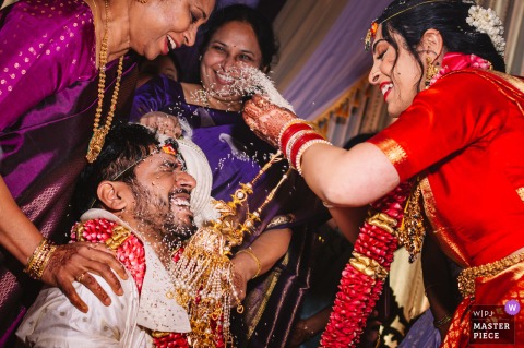 At Riverside on the Potomac, VA, guests joyfully shower the couple with rice during a traditional Hindu wedding ceremony blessing.