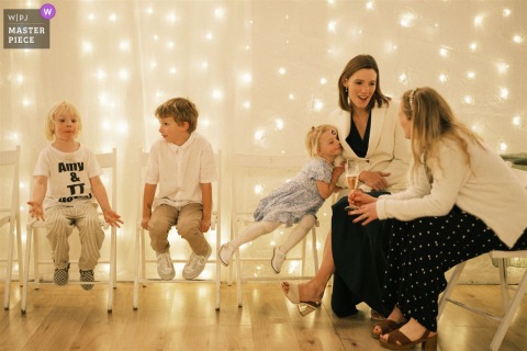 A mother with three children chats as wedding guests eagerly await the couple’s first dance at Breckenhill in County Antrim.