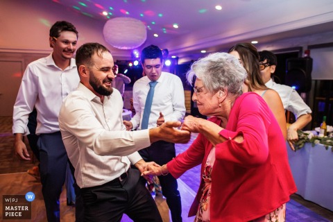 Joyful Guests Dance Energetically Under Vibrant Lights at Lively San Francisco Wedding Reception San Francisco wedding reception with joyful guests dancing energetically under vibrant, colorful lights, capturing lively celebration and festive atmosphere.