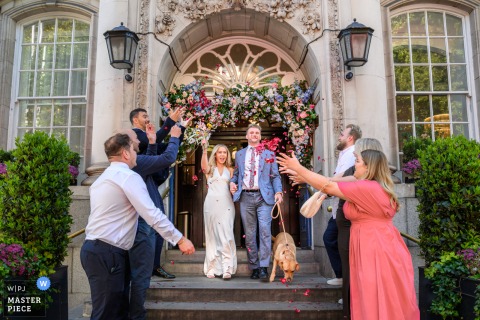 Bride and Groom Leave Kensington and Chelsea Register Office with Their Dog After Wedding Ceremony At the Kensington and Chelsea Register Office, the bride and groom leave with their dog. The award-winning photo highlights the photographer’s skill at documenting joyous moments.