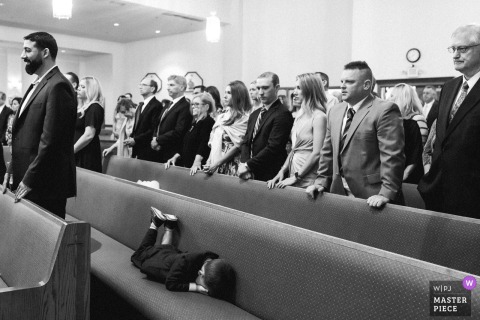 At Saint Martha Church in Kennebunk, Maine, a ring bearer can no longer contain his boredom during the ceremony. The award-winning black-and-white photo highlights the photographer’s skill at documenting humorous moments.