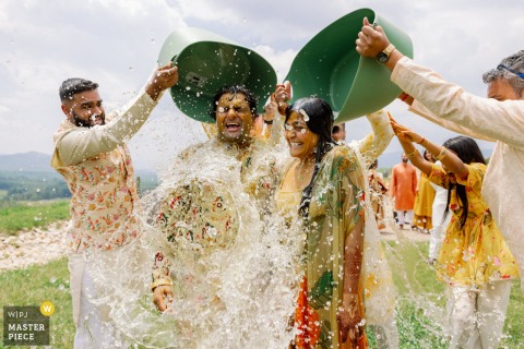 At Hazy Mountain Vineyards in Charlottesville, Virginia, the wedding party dumps water on the couple after the Haldi ceremony. The award-winning photo highlights the photographer's skill at documenting joyful traditions.