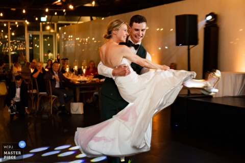 At the Montreal Science Centre, a groom twirls his bride during their first dance, her dress covered in spilled wine. The award-winning photo highlights the photographer’s skill at documenting a perfectly imperfect, joyful moment.