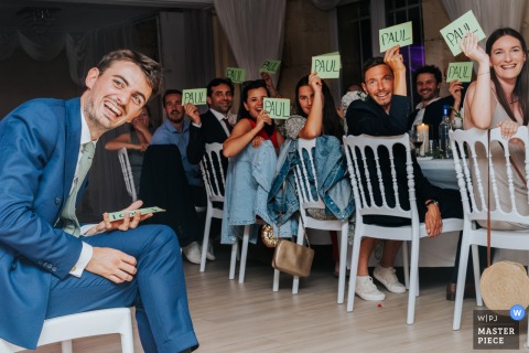 At the Château du Grand Moueys, a game is played with the newlyweds during the evening reception. The award-winning photograph highlights the photographer's skill at capturing candid moments of celebration, joy, and spontaneity during a wedding.