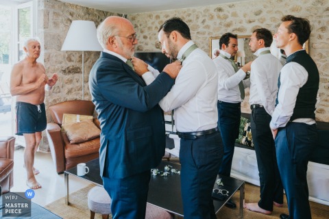 At a home in Maisonnais-sur-Tardoire, Gironde, the groom prepares for his wedding with his father and groomsmen. The award-winning photo showcases the photographer's skill at capturing the sincere, unposed moments of a wedding day.
