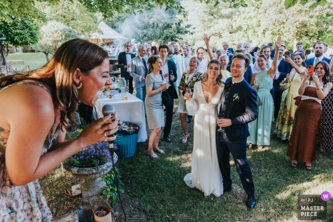 At the reception venue in Maisonnais-sur-Tardoire, Gironde, a wedding guest spontaneously sings during cocktail hour. The award-winning photo highlights the photographer’s skill at capturing the unexpected, genuine moments that make each wedding unique.