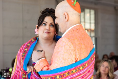During their heartfelt wedding ceremony at Upstairs Atlanta, the bride shares a playful and knowing look with her groom as they stand together before their family and friends.