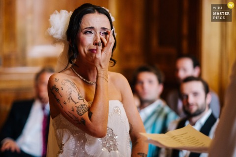 At Hackney Town Hall, the photographer captures the bride wiping tears as she listens to the groom’s vows, expertly freezing raw emotion and heartfelt expression in a beautifully intimate ceremony moment.